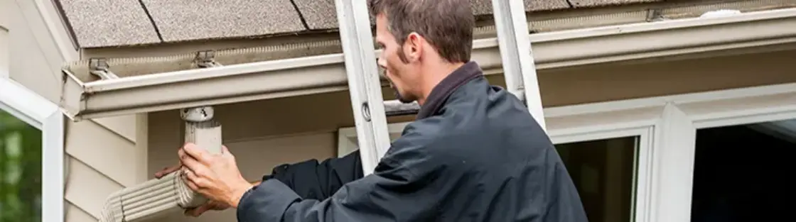 Man cleaning gutter downspouts
