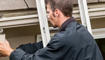 Man cleaning gutter downspouts