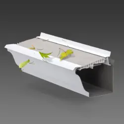 A cross-section of a LeafFilter protected gutter displays its uPVC frame while maple leaves, needles, and spinners shed from the product's screen.