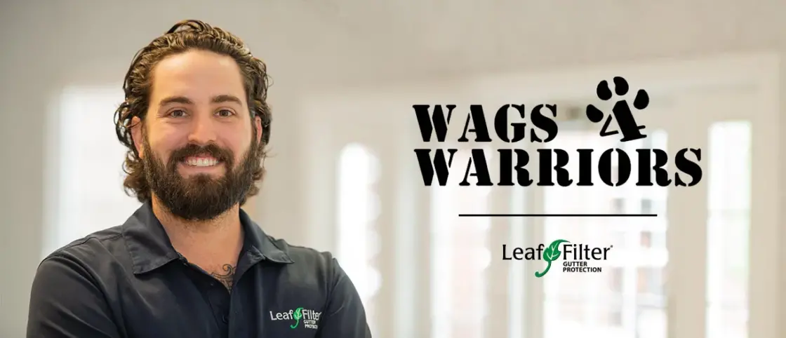 A LeafFilter employee poses in a branded t-shirt next a to a Wags 4 Warriors icon
