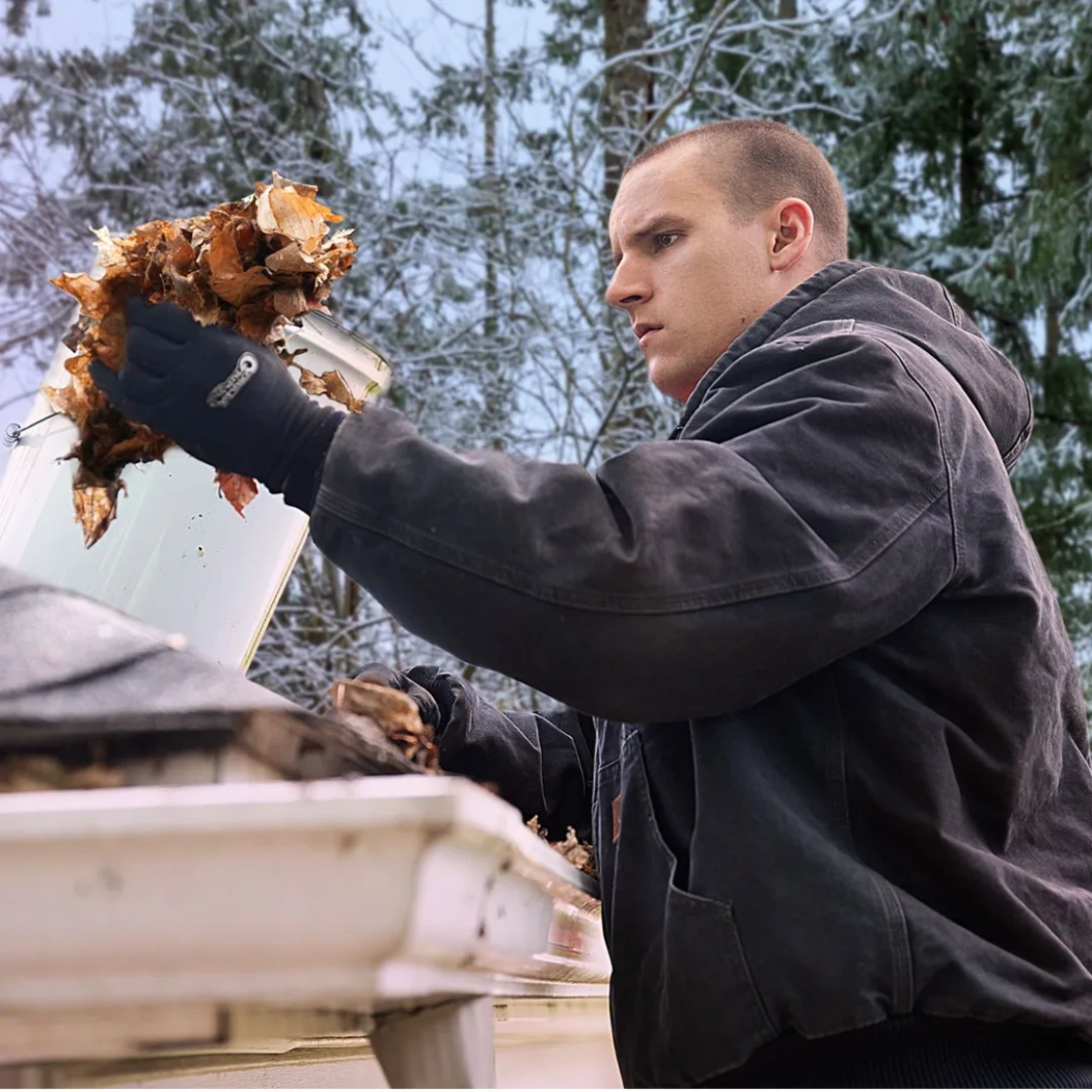 LeafFilter product installer cleaning out gutters for a customer