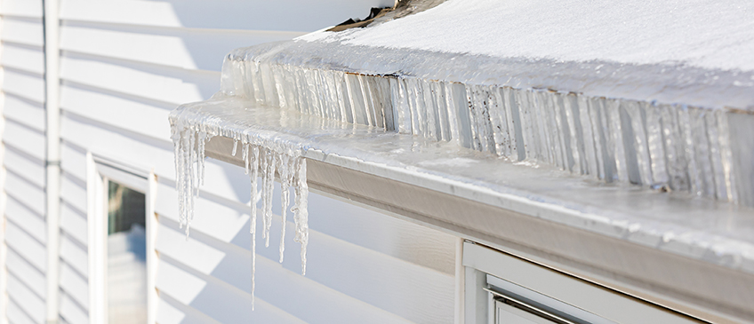 Gutters covered with snow, ice, and icicles