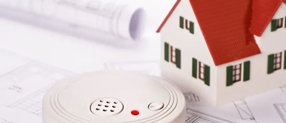 Smoke detector and small model home on top of home evacuation plans - home fire prevention and preparation