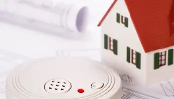 Smoke detector and small model home on top of home evacuation plans - home fire prevention and preparation