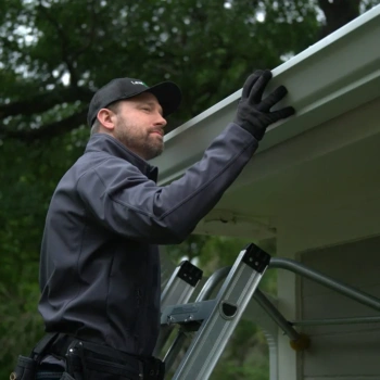 leaf filter installer looking at roof line. leaf filter installed beautiful home lush green yard