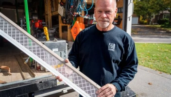 Mike Holmes holding LeafFilter gutter guard in front of work van to promote LeafFilter and Mike Holmes partnership