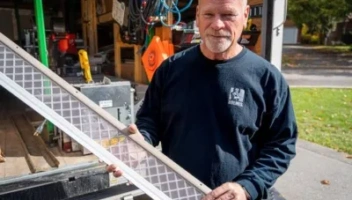 Mike Holmes holding LeafFilter gutter guard in front of work van to promote LeafFilter and Mike Holmes partnership