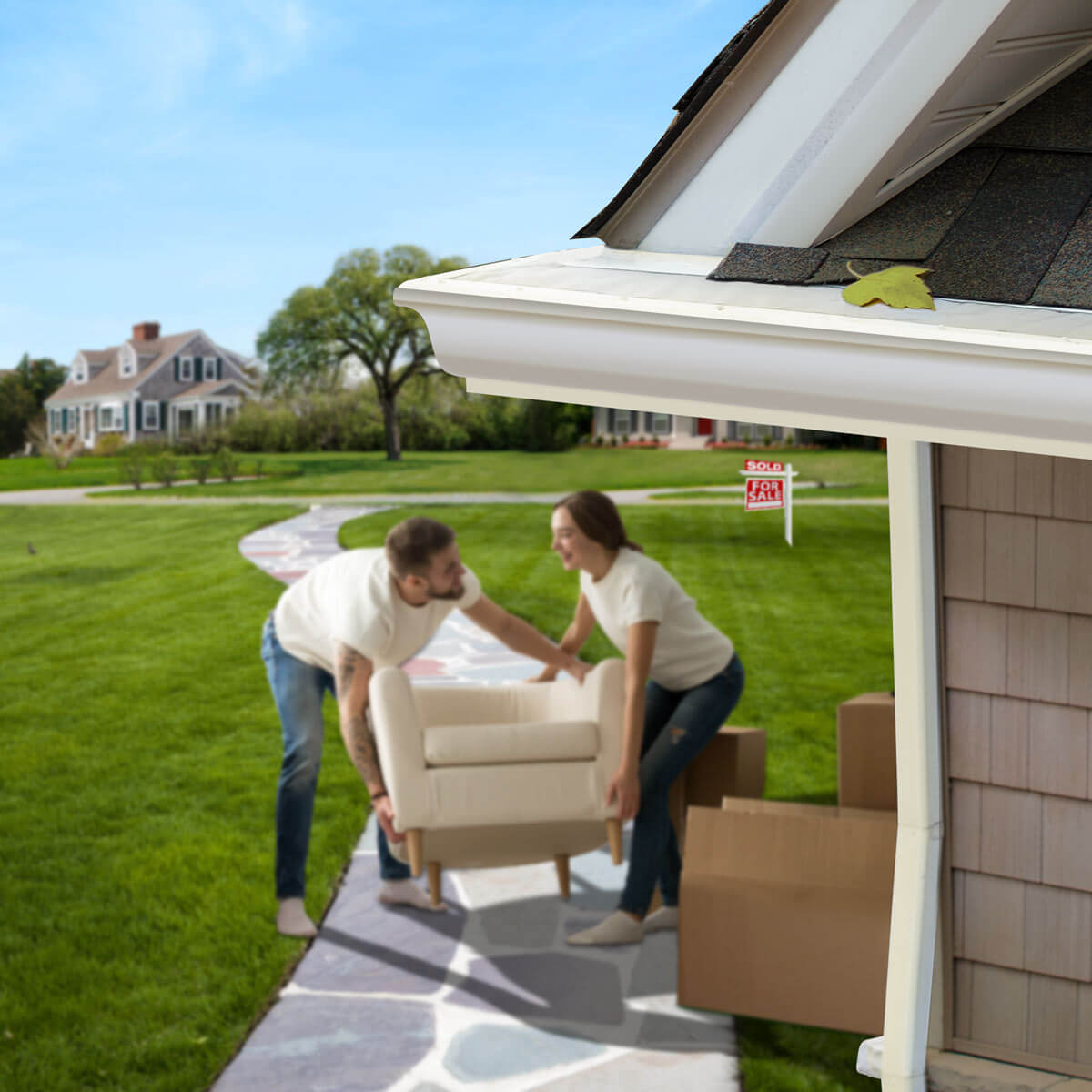 A couple moves an armchair into their recently purchased home under LeafFilter-protected gutters